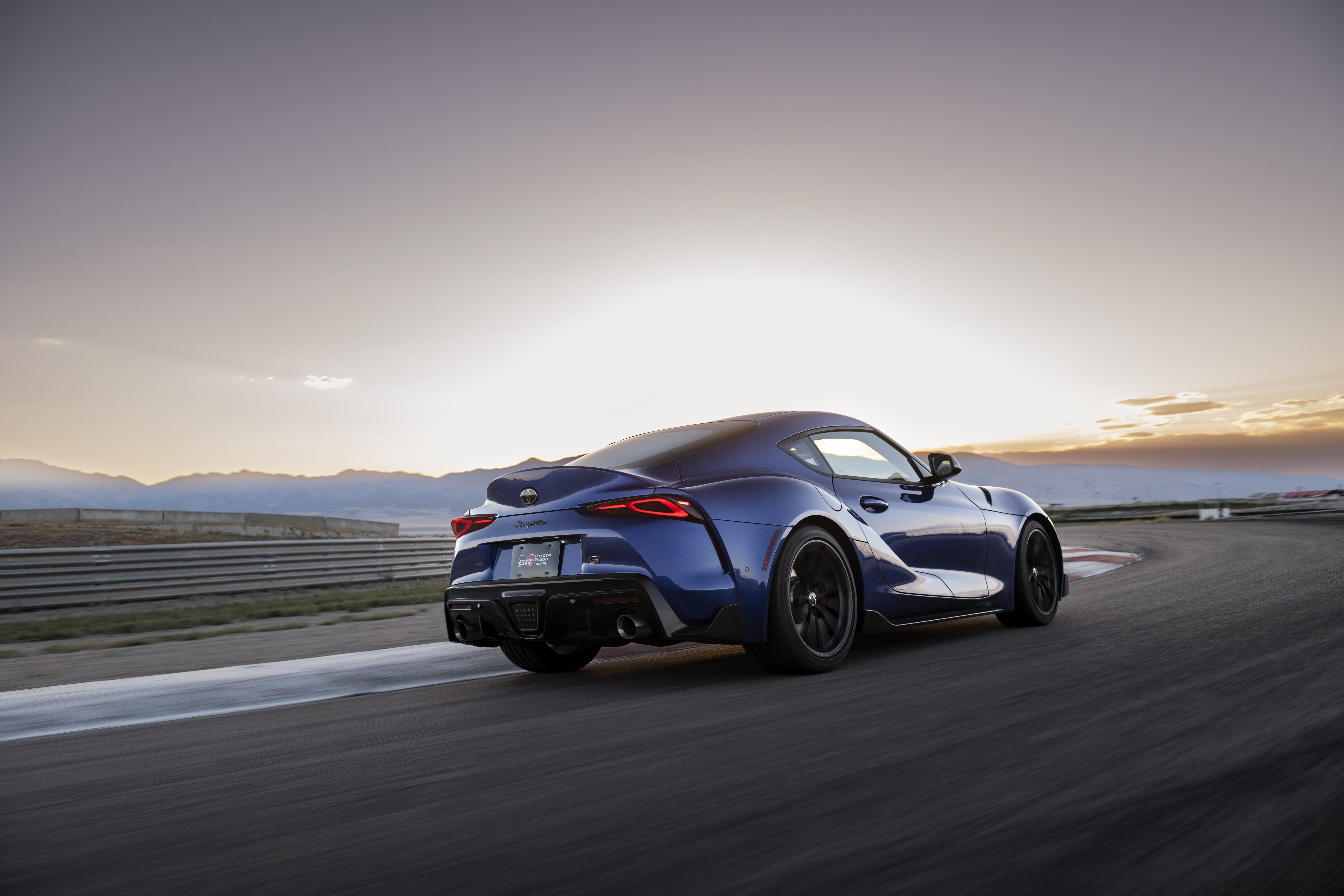 Toyota Supra GR Manual color -Stratoshpre Blue- cornering into the sunset.